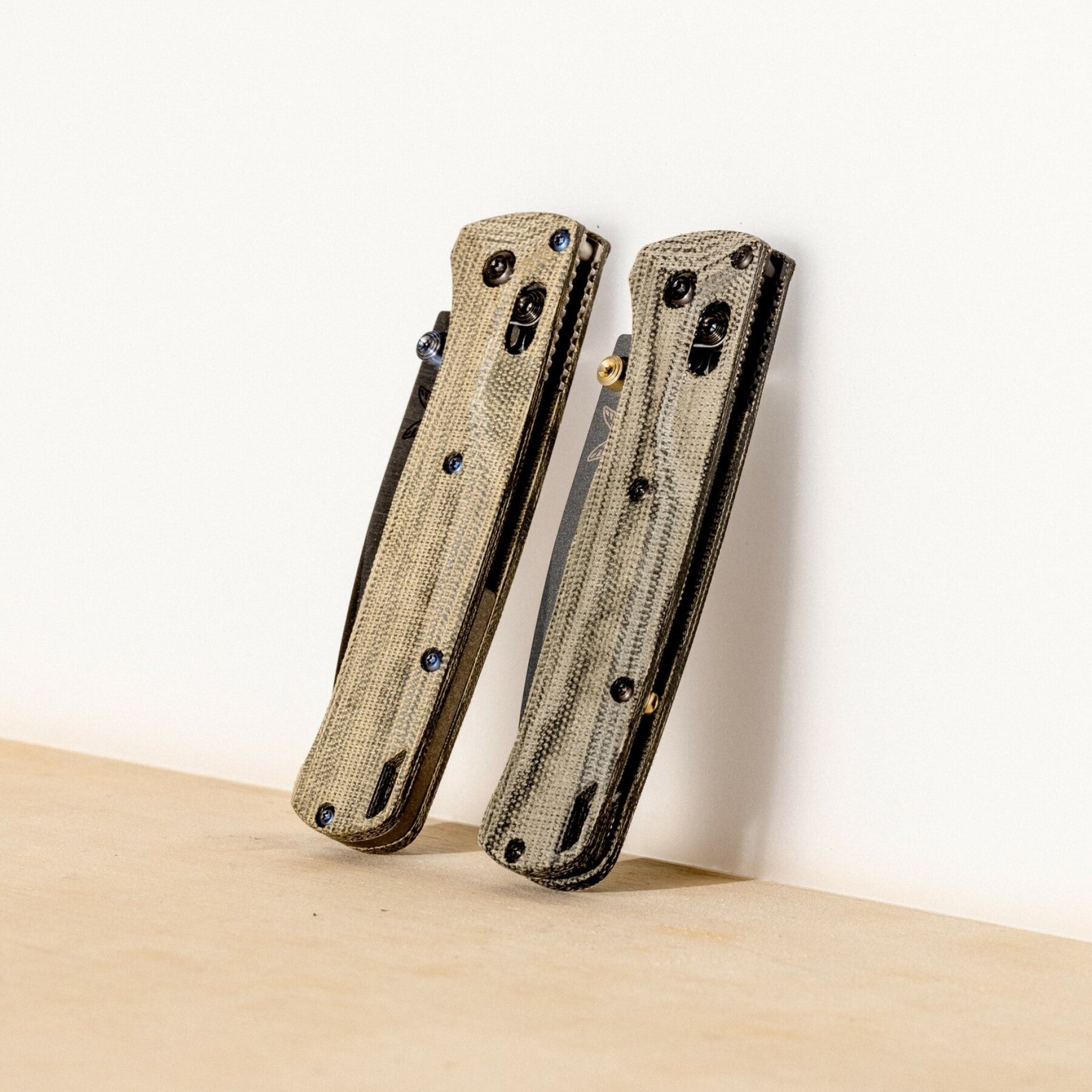 A pair of Benchmade Bugout knives with micarta handles.